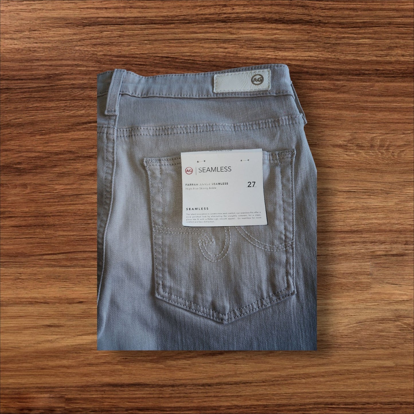 Folded pair of jeans with a tag on a wooden surface