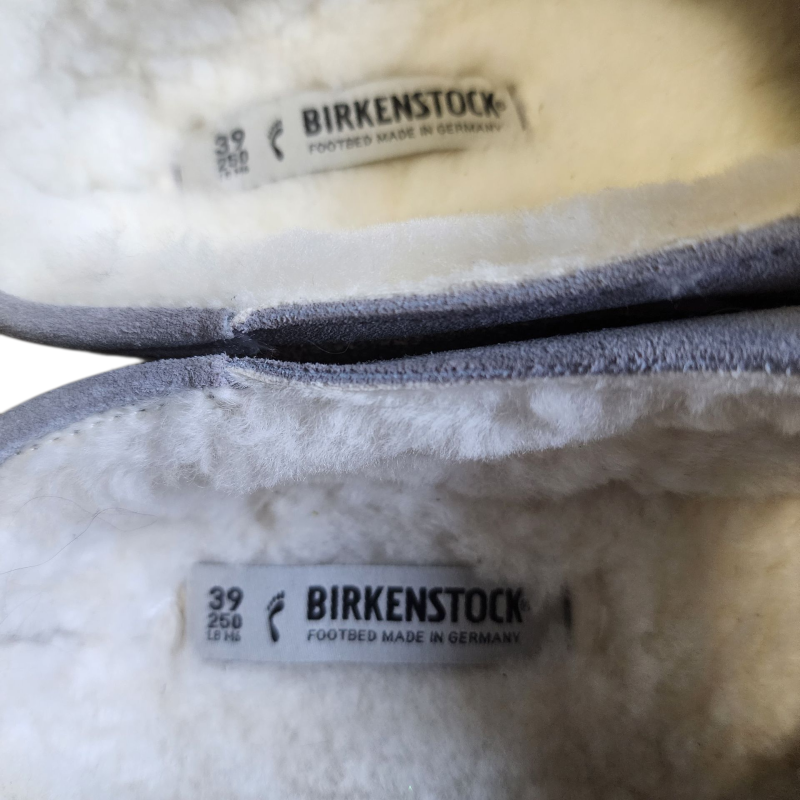 Close-up of Birkenstock slippers with brand labels on a white background