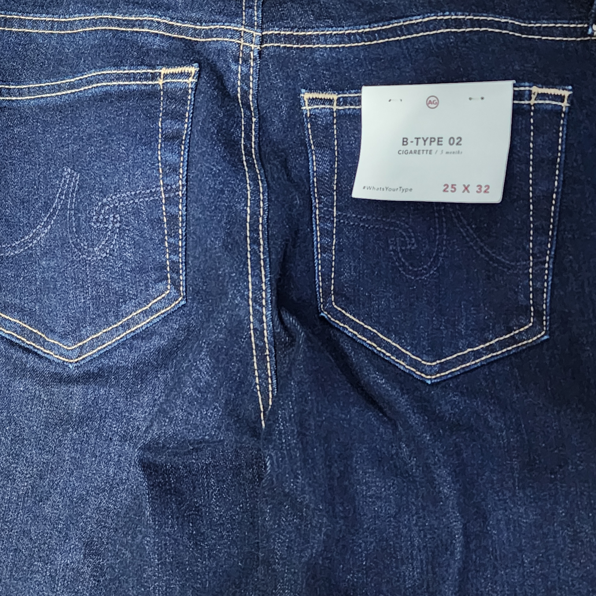 Close-up of blue denim jeans with a size label on the back pocket.