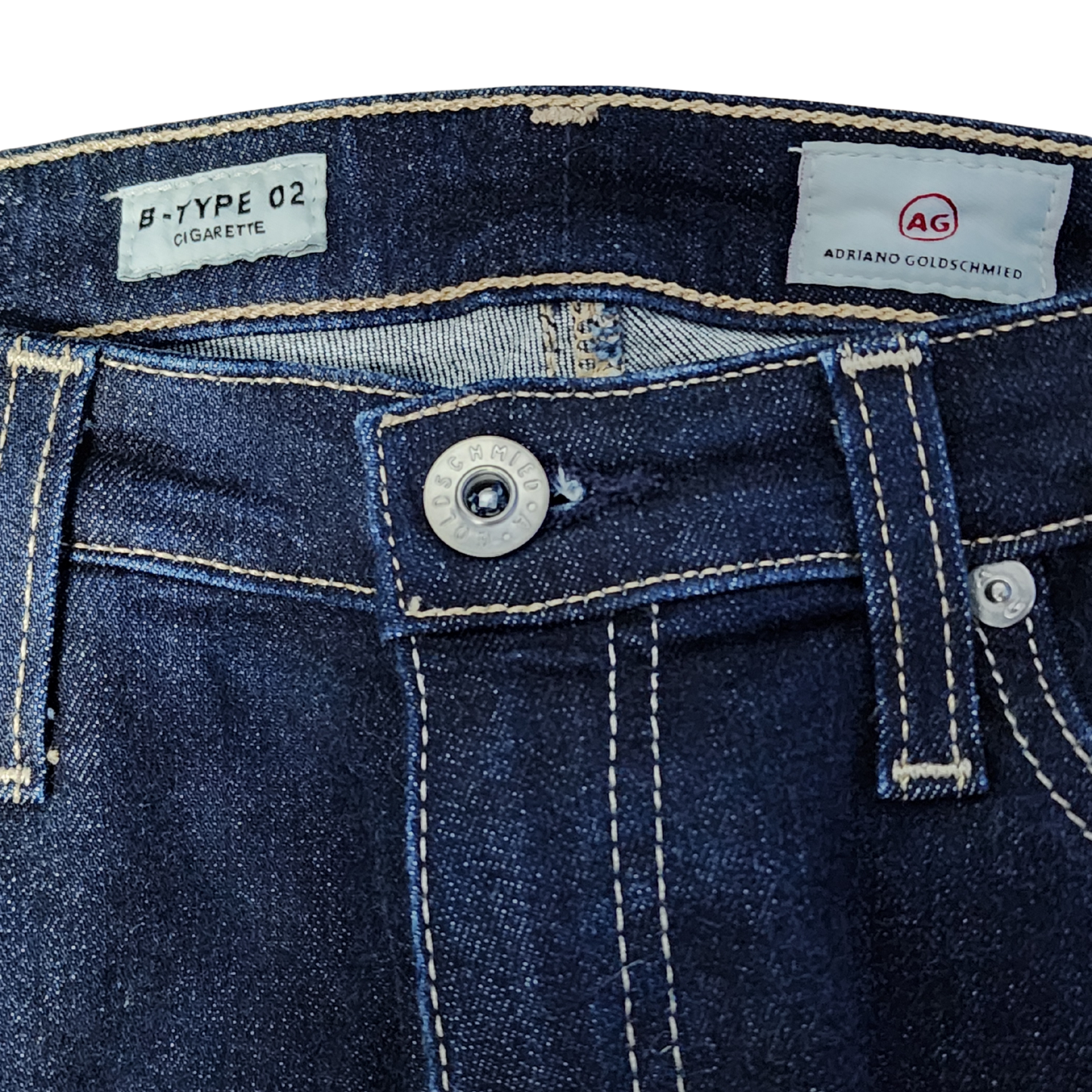Close-up of blue denim jeans with AG Adriano Goldschmied label.
