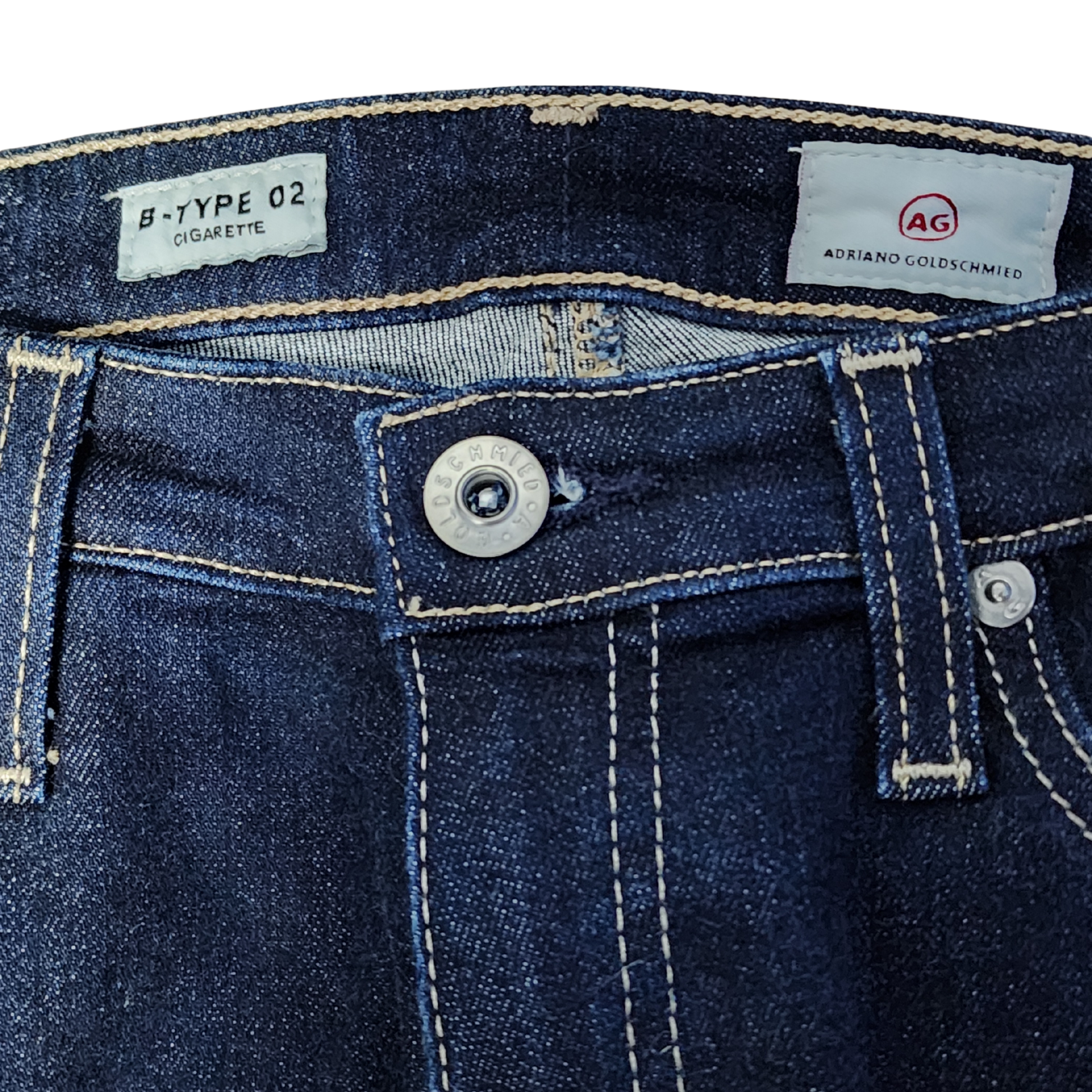 Close-up of blue denim jeans with AG Adriano Goldschmied label.