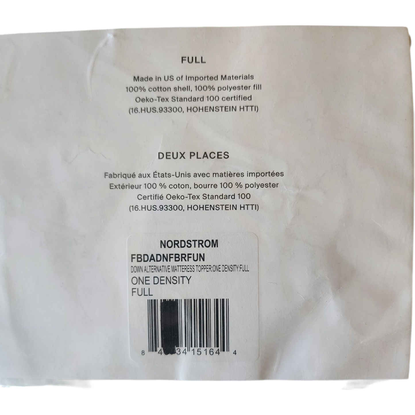 Back of a mattress cover with text and a barcode on a white background