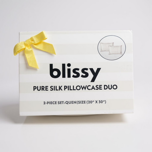 Blissy pure silk pillowcase duo packaging with a yellow ribbon on a light gray background