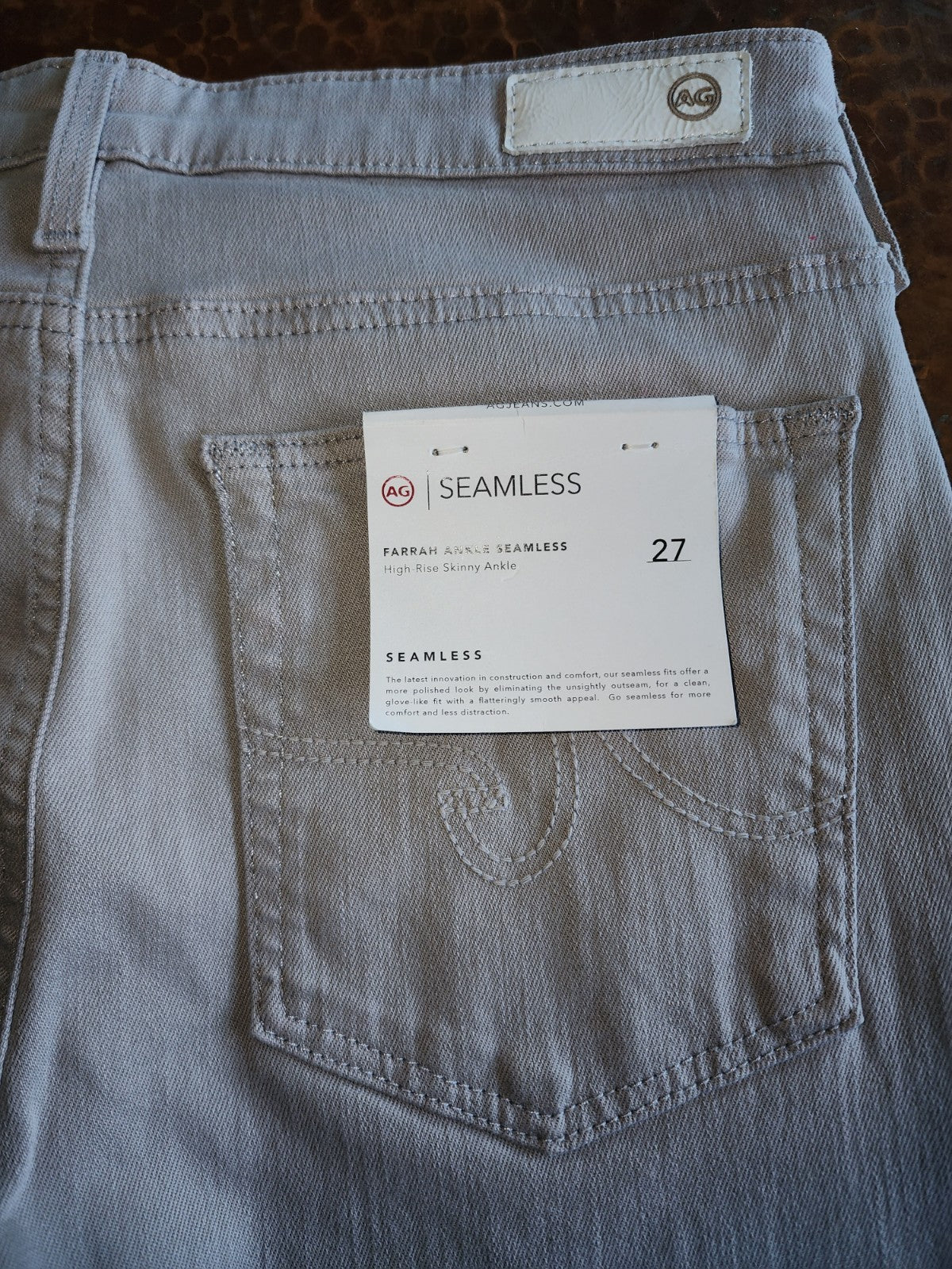 Gray jeans with a size tag on the pocket, brand label visible.